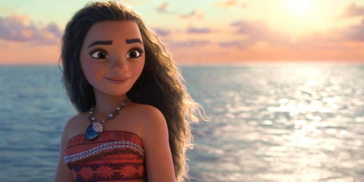 An animated girl with long, wavy hair stands on a boat in the ocean, wearing a red patterned dress and a seashell necklace. The sun sets behind her, casting a warm glow over the water.