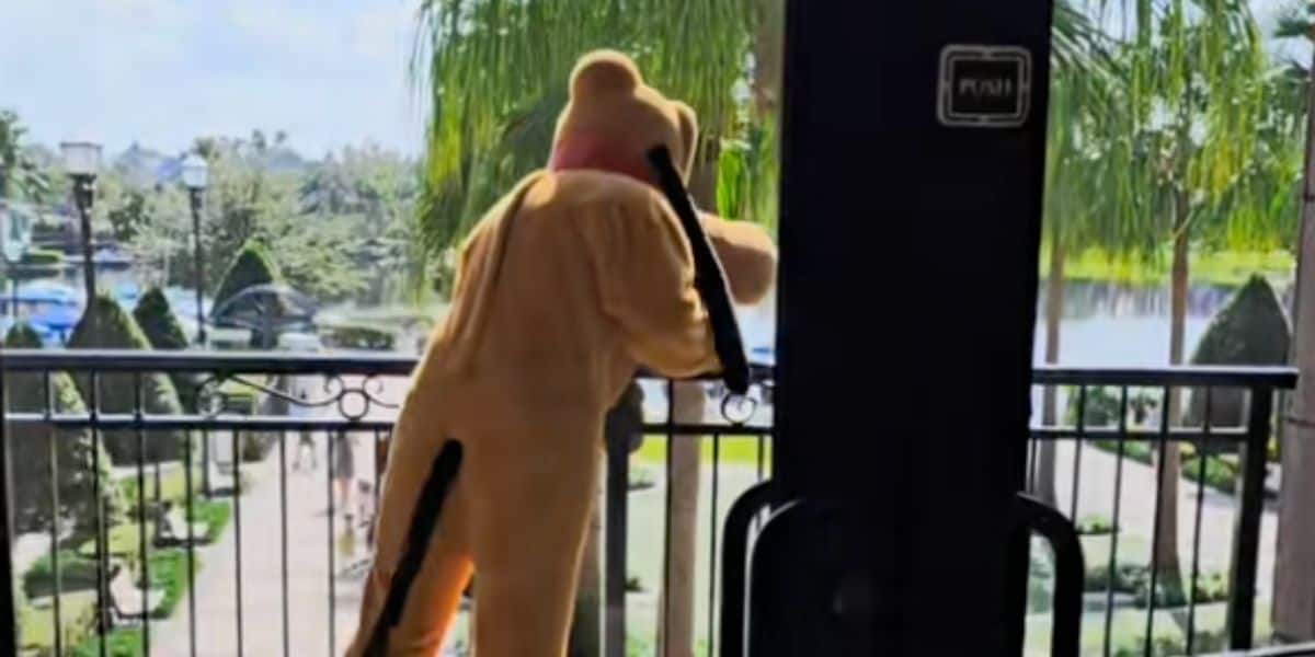 Pluto, one of two Disney characters punched by a child, stands on a balcony to "cool down."