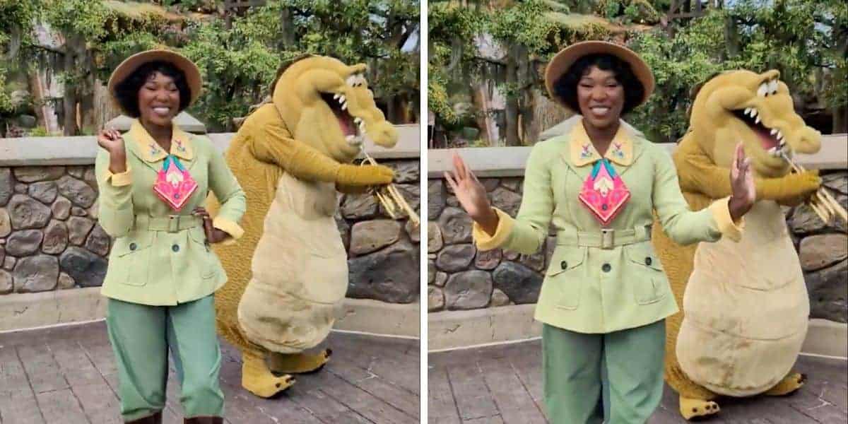A person wearing a green outfit and hat, dances joyfully alongside someone in an alligator costume. They are outdoors, with a stone wall and greenery in the background, exuding a lively and cheerful atmosphere.