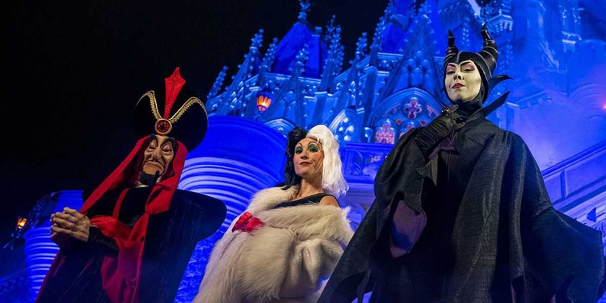 Jafar, Cruella de Vil, and Maleficent in front of Cinderella Castle