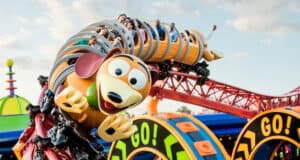 Roller coaster shaped like Slinky from Toy Story, with people riding inside the coils.