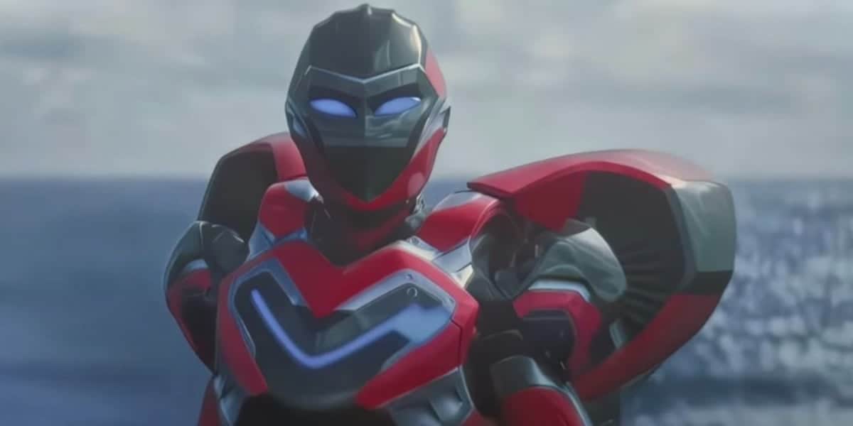 A futuristic robot in red, black, and silver armor with glowing blue eyes stands in front of a blurred ocean background.