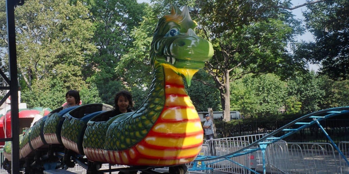 Children riding a dragon kiddie coaster. 