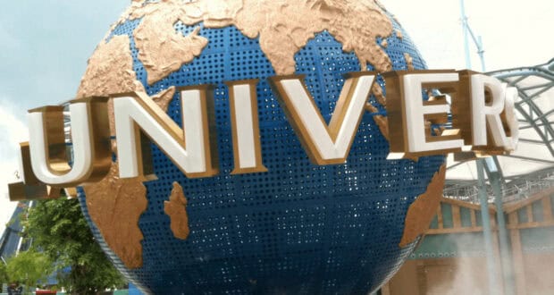 A large blue and gold globe with the word "UNIVERSAL" in bold white letters, located at the entrance of Universal Studios theme park.