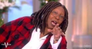 A woman with long dreadlocks and glasses, wearing a red and black plaid jacket over a white shirt, gestures animatedly while speaking on the set of "The View." The show's logo appears in the corner.
