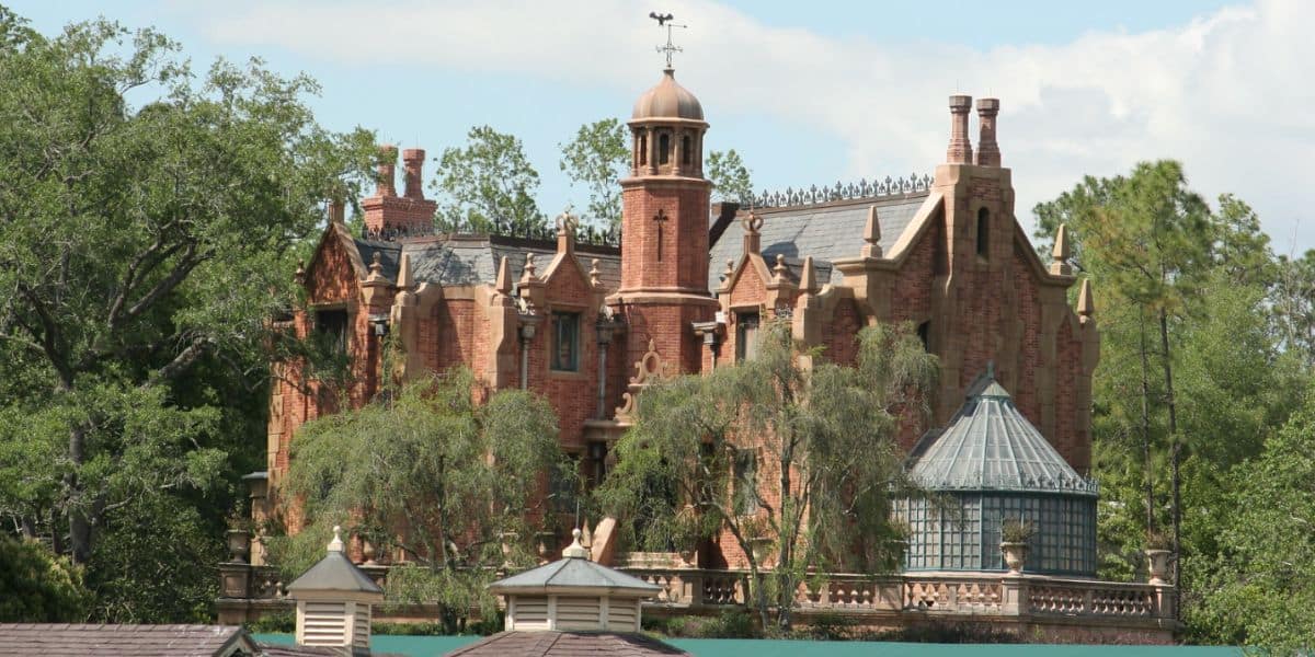 The exterior of the Haunted Mansion at Magic Kingdom Park on a clear day.