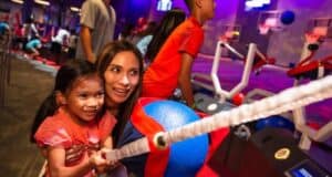 Guests enjoy Disney’s ball-toss arcade game, sharing smiles and excitement in a vibrant theme park arcade atmosphere.