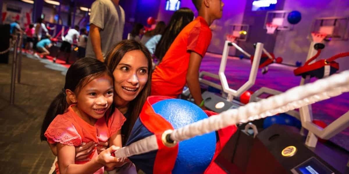 Guests enjoy Disney’s ball-toss arcade game, sharing smiles and excitement in a vibrant theme park arcade atmosphere.