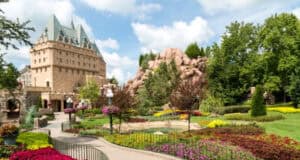 Fairytale stone castle surrounded by vibrant gardens, set against a bright sky—reminiscent of Disney Parks’ magical atmosphere.