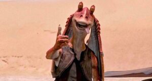 Jar Jar Binks greets visitors with a thumbs up in a Star Wars-inspired desert scene at the theme park.