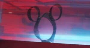A classic Hidden Mickey silhouette glows under red and blue lights, capturing Disney World’s secret-spotting tradition.