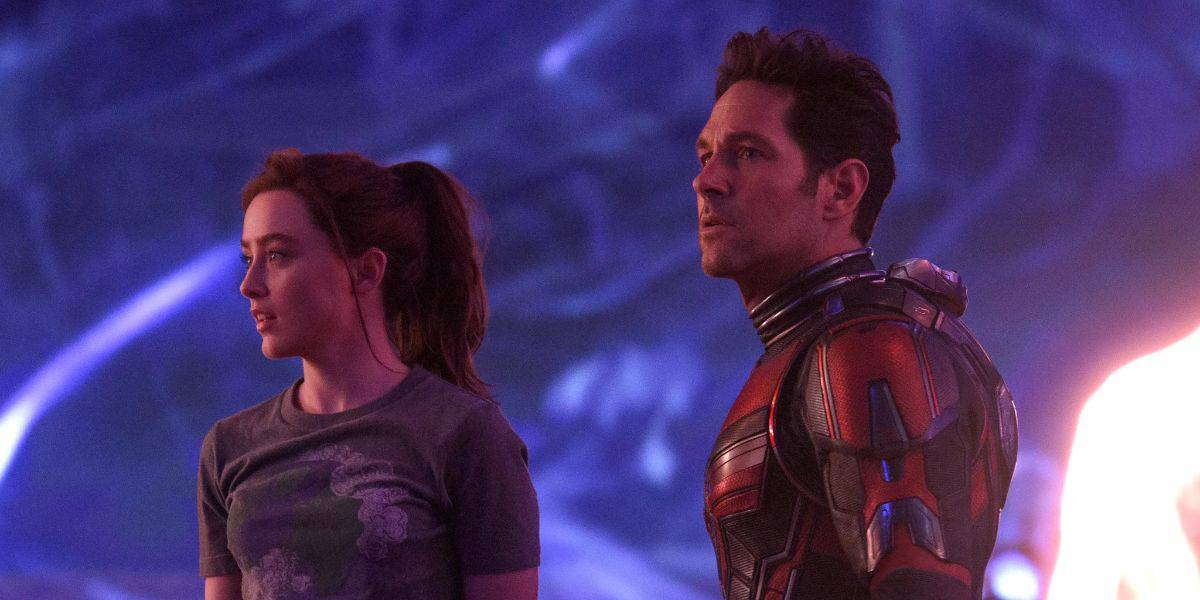 An Avengers: Doomsday hero poses beside a casually dressed guest under vibrant lights, capturing a thrilling park moment.