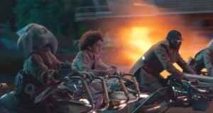 Guests in vibrant costumes, including a rabbit-helmet rider, speed on hoverbikes past fireworks like a Mandalorian live show.