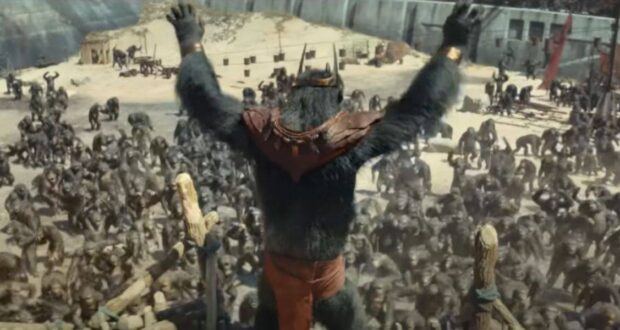 Caesar raises his arms before a gathering of apes in a walled area, recalling a scene from Planet of the Apes.