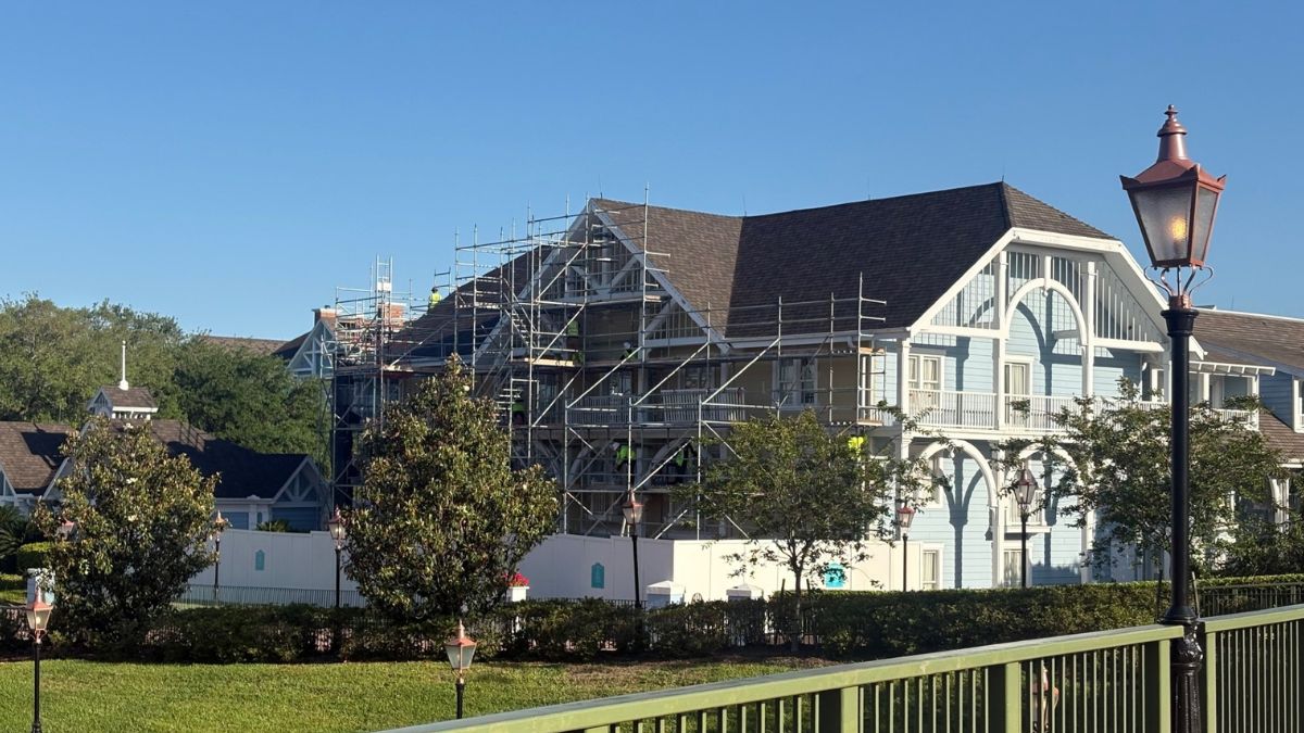 Disney's Beach Club Resort in light blue, surrounded by trees and lamppost, is under refurbishment with scaffolding visible.