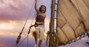 A guest beams with excitement aboard a sailboat, soaking up the magic of a sunset cruise on Disney’s Seven Seas Lagoon.
