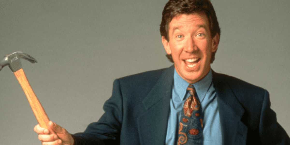 Energetic host in a suit wields a hammer, channeling Tim Allen’s Home Improvement vibe, ready for the next theme park show.