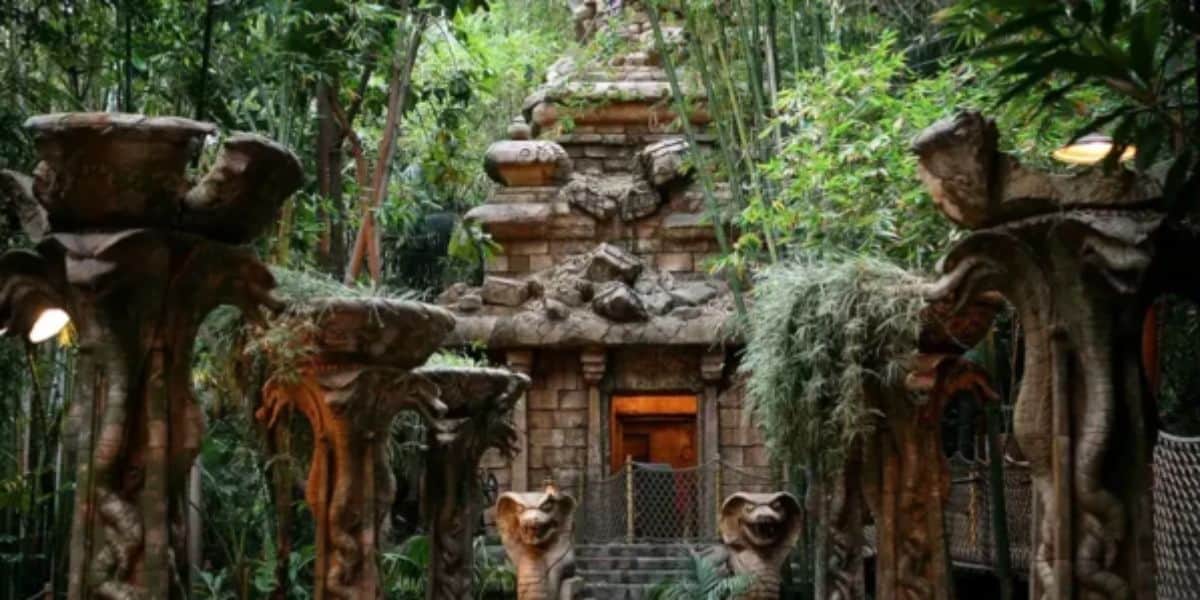 Indiana Jones Adventure temple nestled in thick Disneyland jungle, with iconic statues and flourishing greenery flanking the path—bringing epic adventure vibes even when the attraction is temporarily closed.