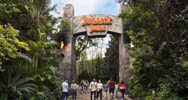 Guests pass through the Jurassic Park gates at Universal Orlando.