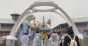 Guests pass beneath the Tomorrowland entrance arch at Magic Kingdom.