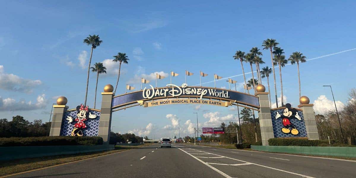 Minnie and Mickey Mouse at the Walt Disney World entrance arch.