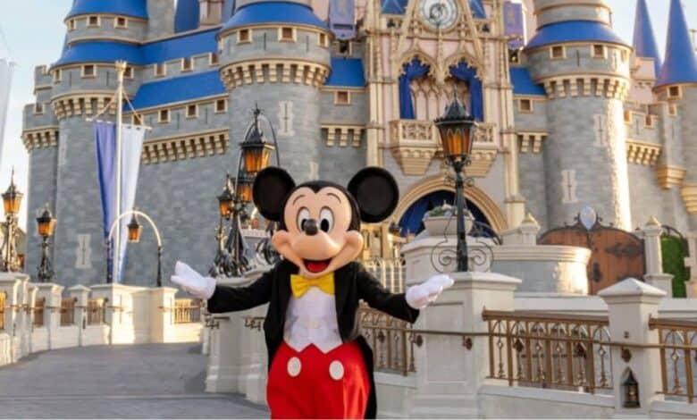 Mickey Mouse posing in front of Cinderella Castle at Disney World.