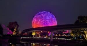 Spaceship Earth glowing with colorful lights at Epcot, Walt Disney World at night.