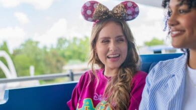 Two guests wearing Minnie ears riding the Tomorrowland Transit Authority PeopleMover at Walt Disney World.