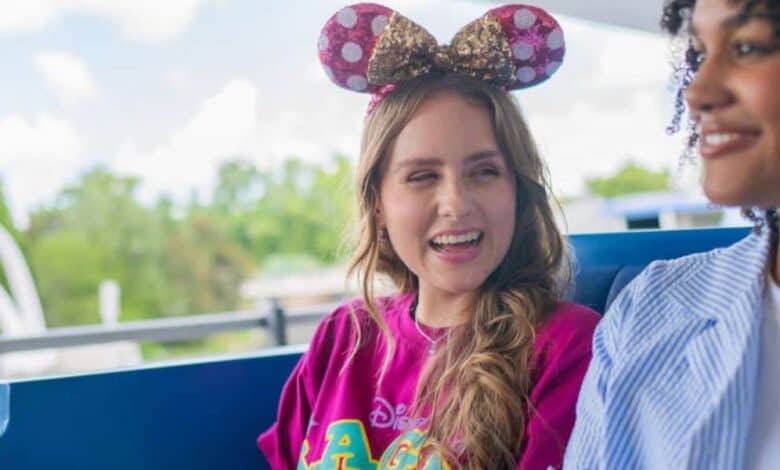 Two guests wearing Minnie ears riding the Tomorrowland Transit Authority PeopleMover at Walt Disney World.