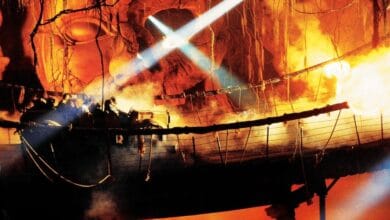 An Indiana Jones Adventure ride vehicle crosses the rope bridge amid fire effects.
