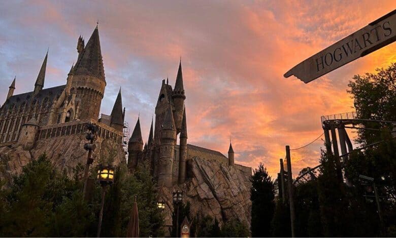 Hogwarts Castle at The Wizarding World of Harry Potter silhouetted against a sunset sky.