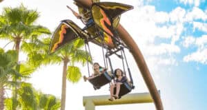 Two children on Pteranodon Flyers at Jurassic Park.