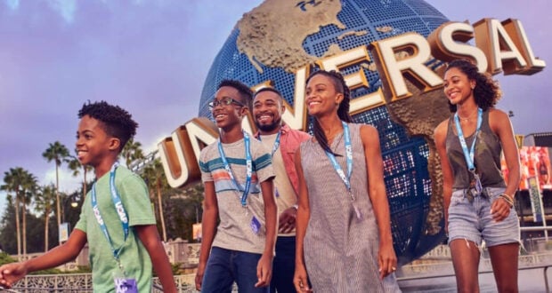 A family walking in front of the Universal Orlando globe.