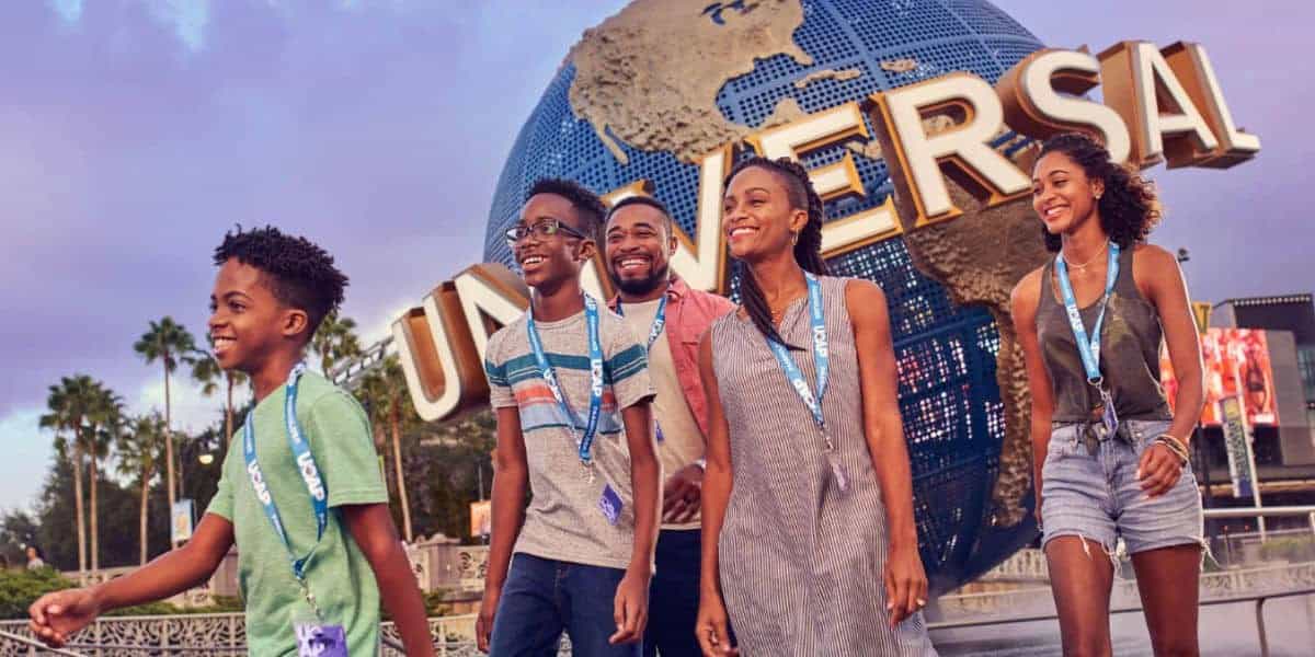 A family walking in front of the Universal Orlando globe.