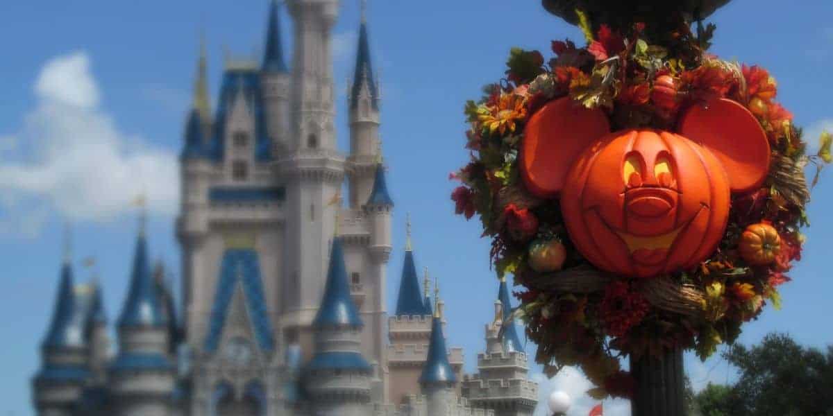 Mickey-shaped pumpkin wreath in front of Cinderella Castle, a highlight of the Disney World holiday season.