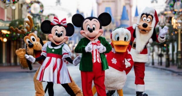 Mickey, Minnie, Donald, Goofy, and Pluto in holiday outfits on Main Street at Disney World.