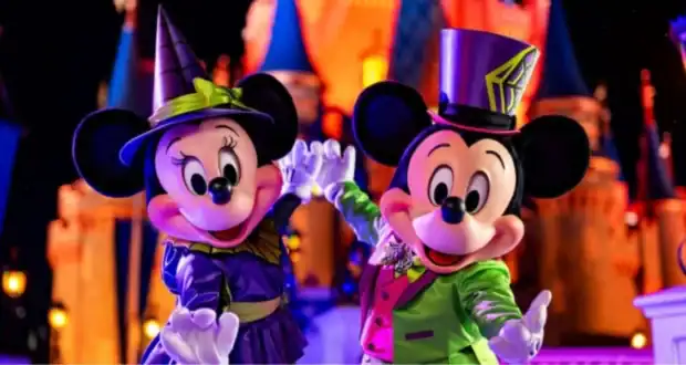 Mickey and Minnie Mouse in Halloween costumes in front of Cinderella Castle at Magic Kingdom near It’s a Small World at Disney World.