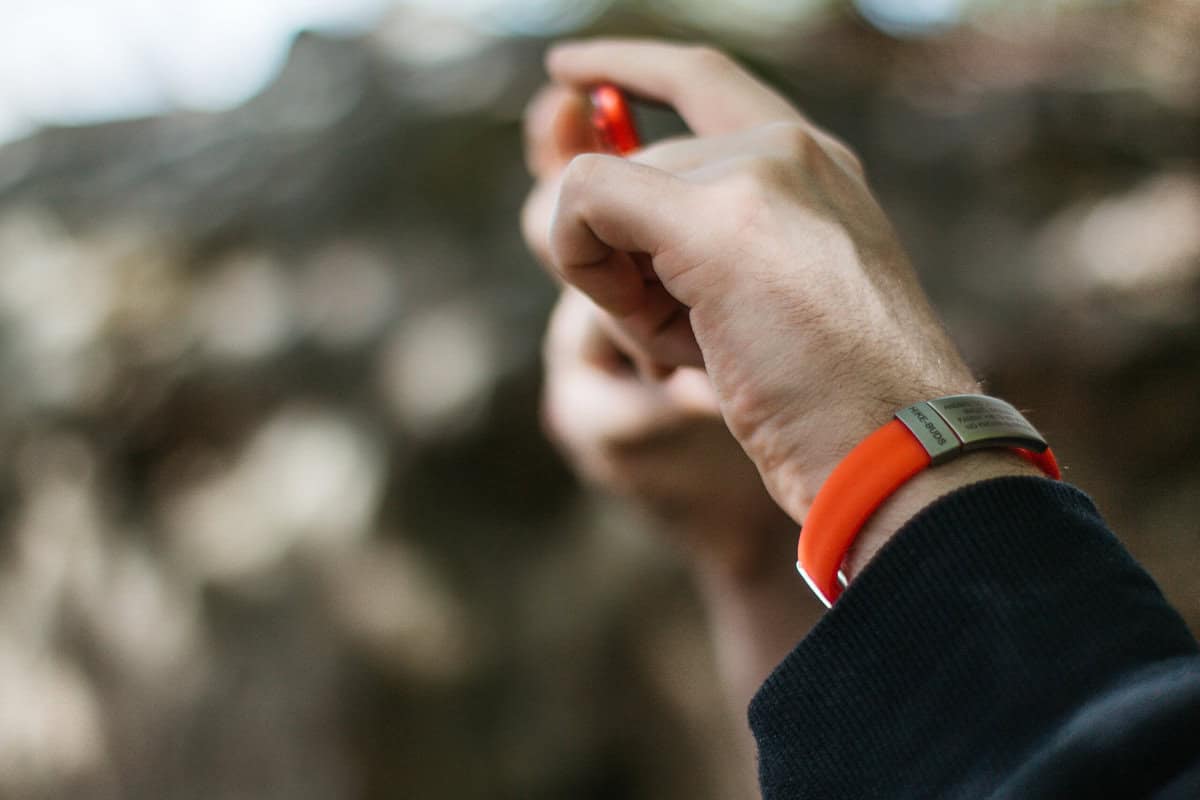 DJUVA Beat ID armbånd: Orange ID-armbånd med en sølvgraveret plade.