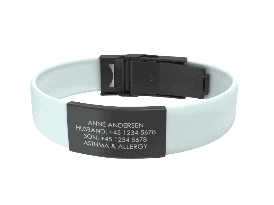 DJUVA Trim ID-armbånd: Hvidt silikone-ID-armbånd med sort graveret plade, der viser kontakt- og medicinske oplysninger.