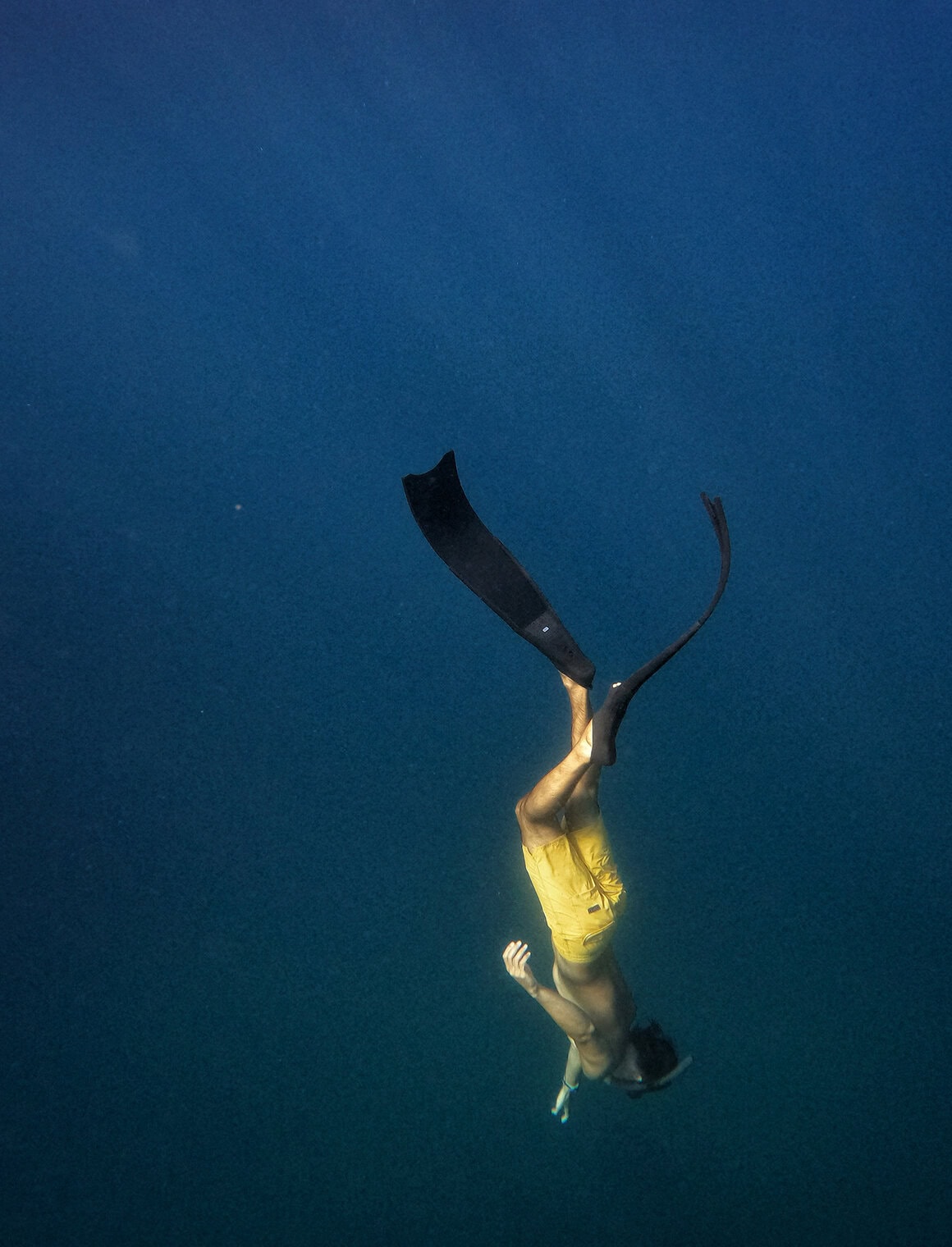 Waterproof backpack submerged underwater with a person swimming, showcasing durability and water res.