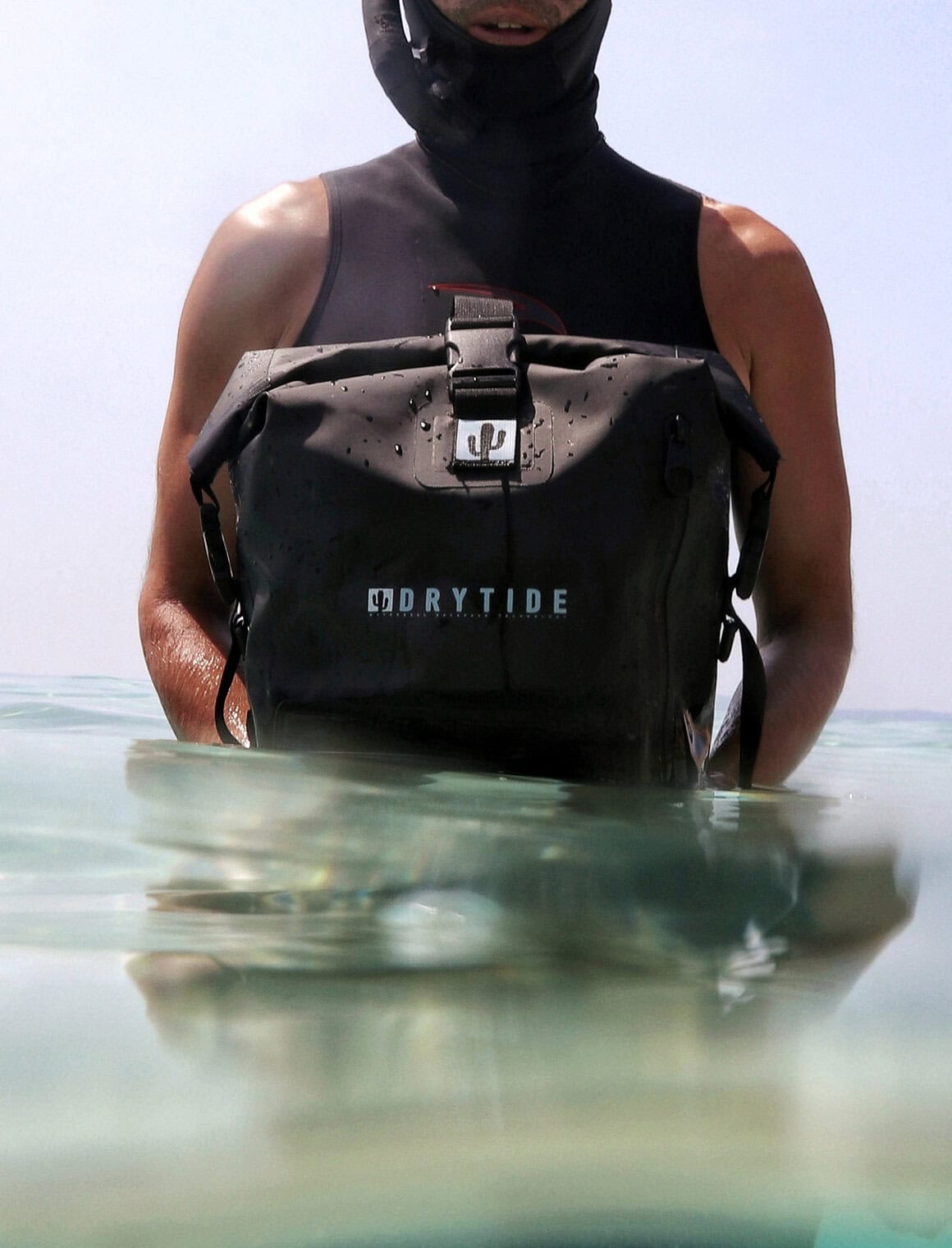 Waterproof backpack submerged in water with a person holding it, showcasing durability and water res.