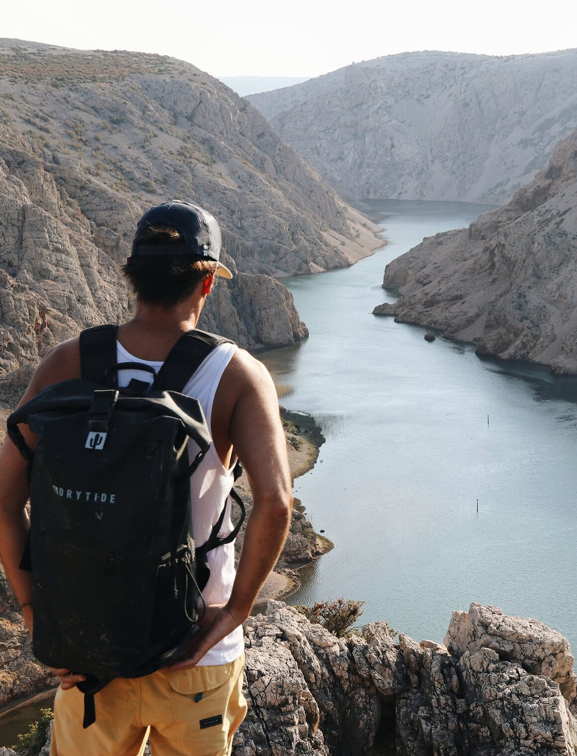 DryTide waterproof backpack on hiker overlooking canyon and river scene.