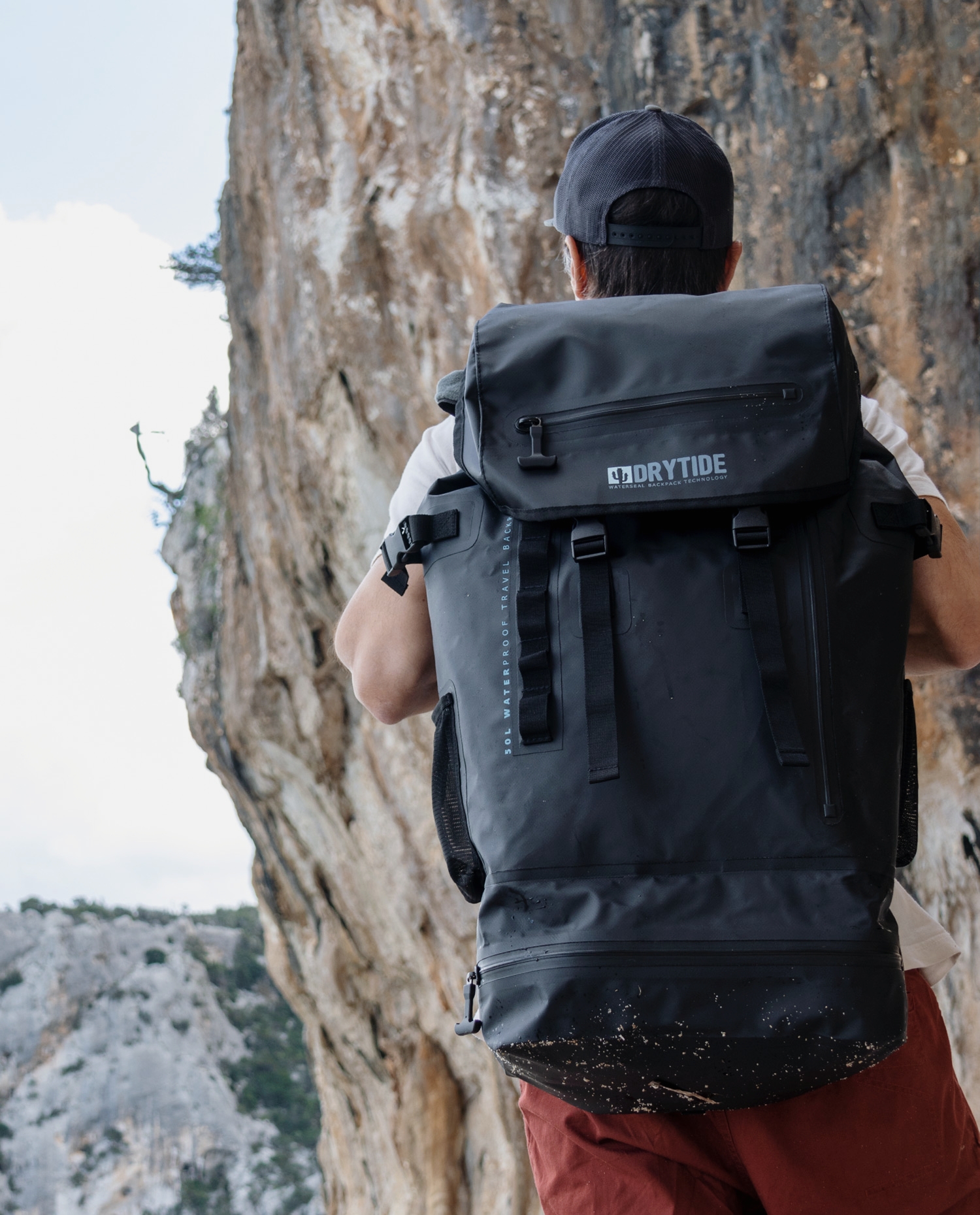 DryTide waterproof backpack on hiker in outdoor mountain setting.
