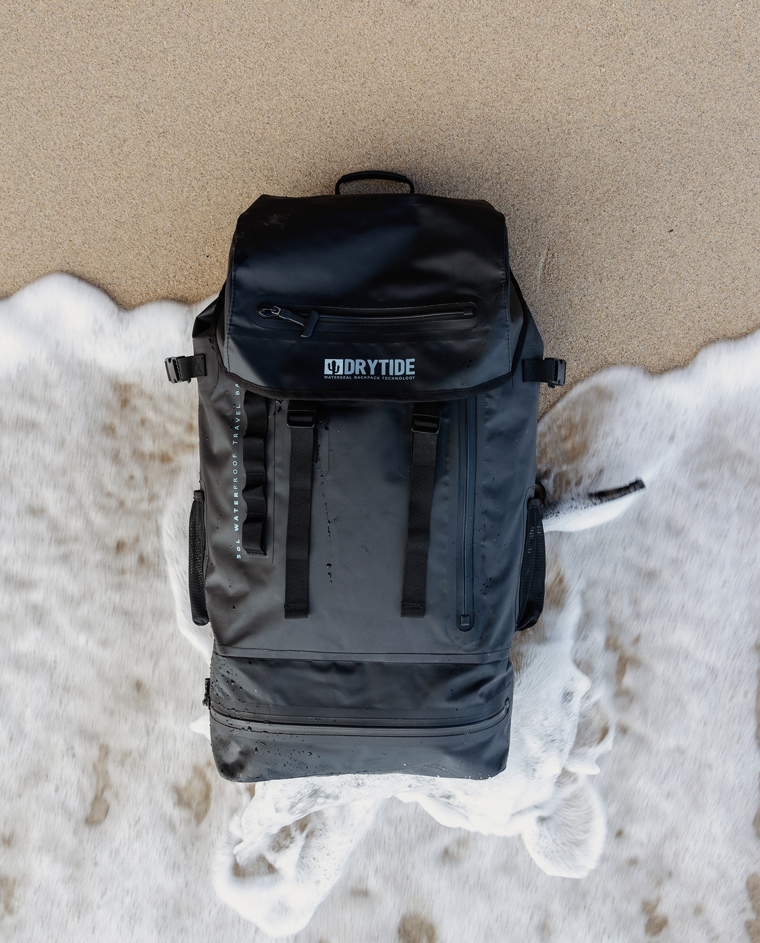 DryTide waterproof backpack with multiple compartments on sandy surface.