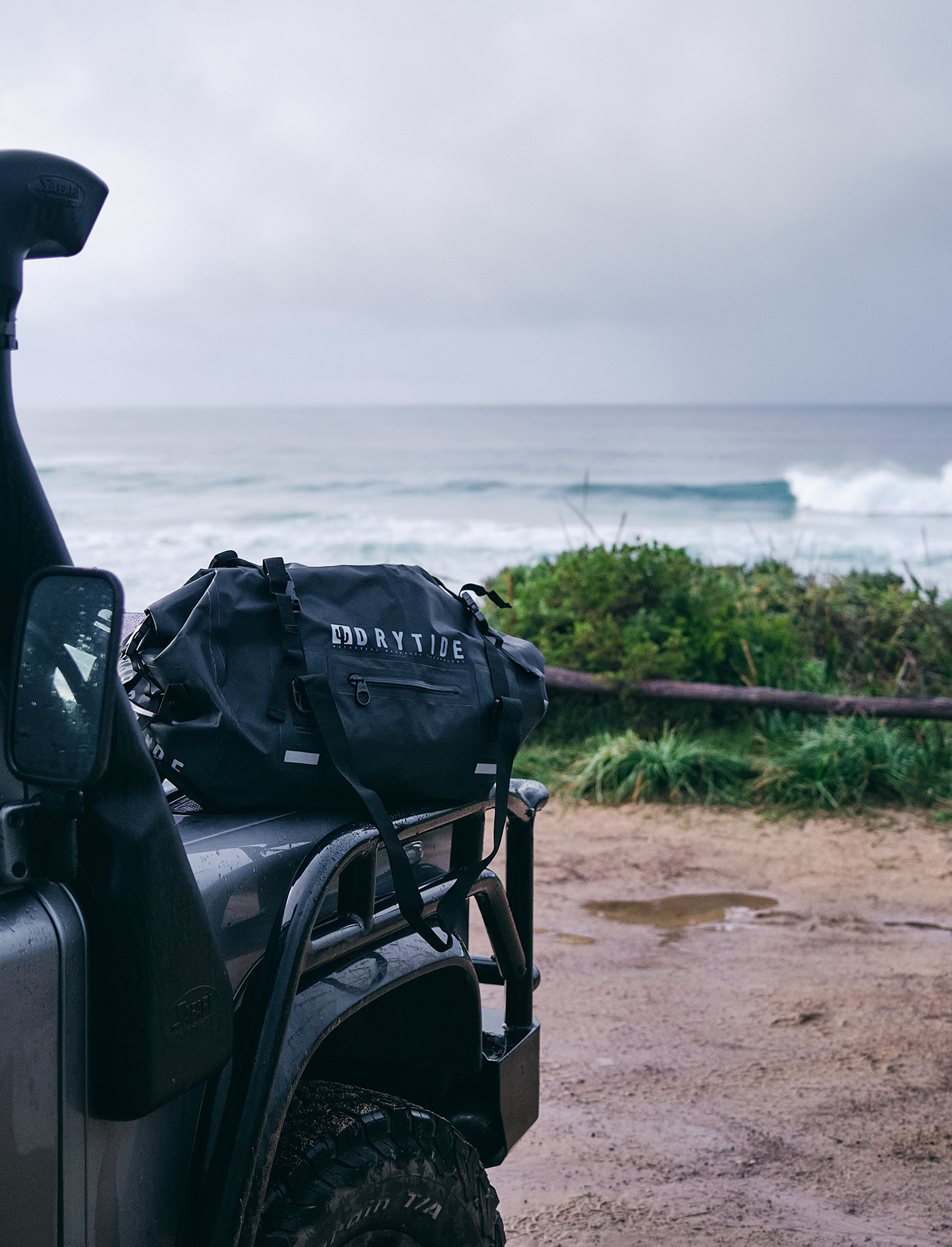 Waterproof backpack on a vehicle near the ocean, ready for outdoor adventures.