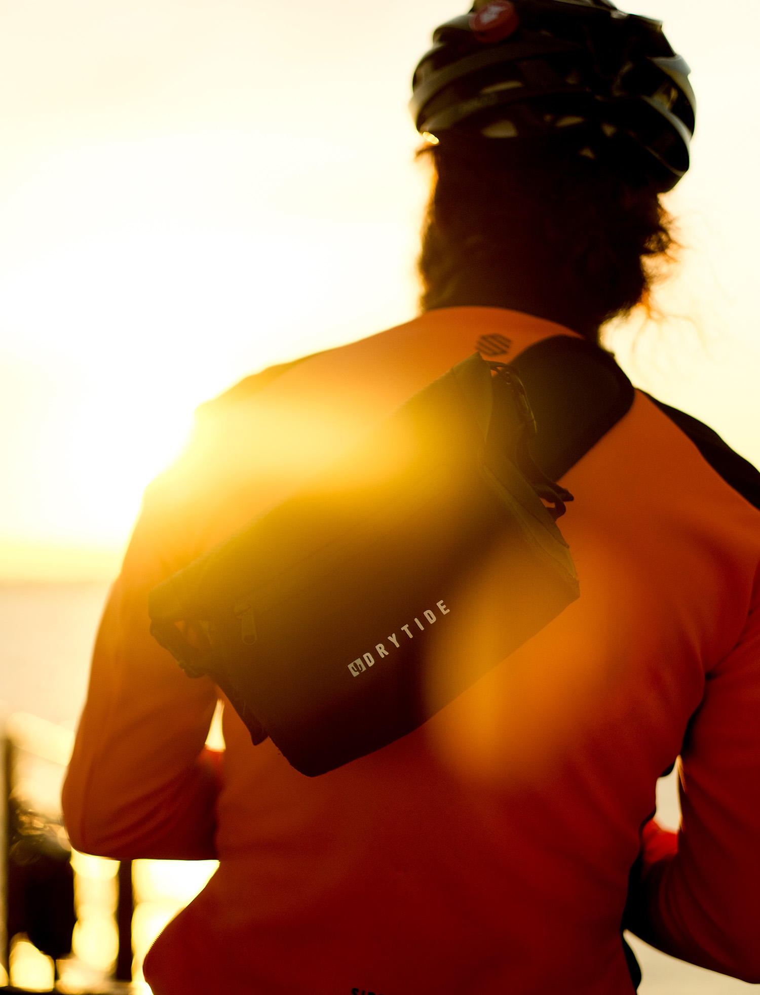 DryTide waist bag portugal Waterproof backpack worn by cyclist at sunset, showcasing dry gear for outdoor adventures.