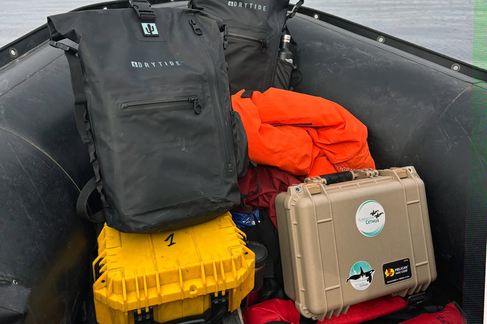 Drytide waterproof gear including backpacks, duffels, and dry bags in boat.