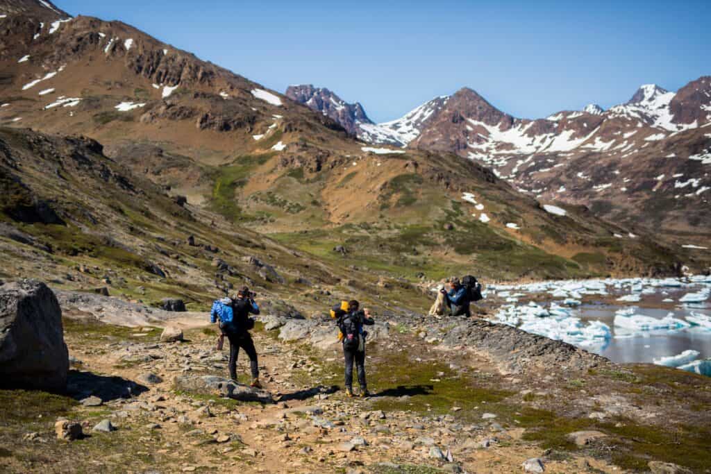 Three hikers with dog outside Tasiilaq.