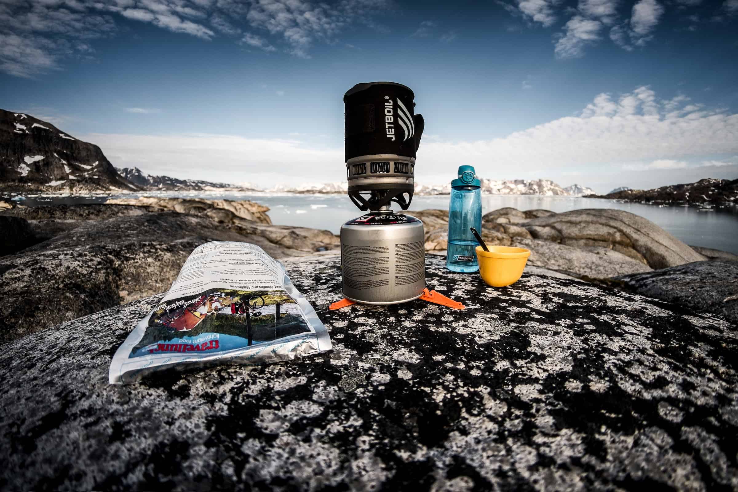 Cooking gear and freeze dried food on a rock near Kulusuk in East Greenland. Photo by Mads Pihl - Visit Greenland
