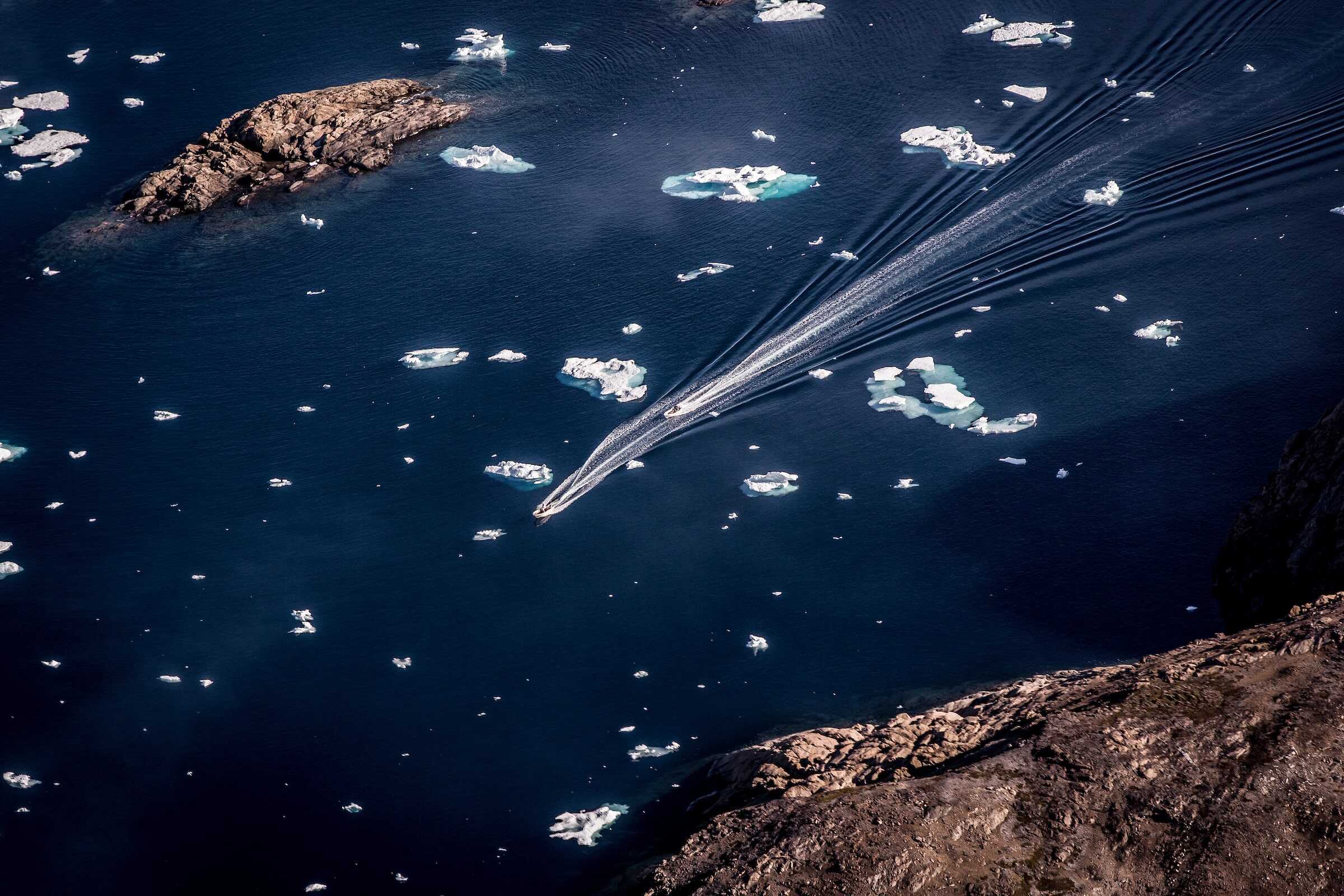 Two small boats along the coastline in East Greenland near Tasiilaq.